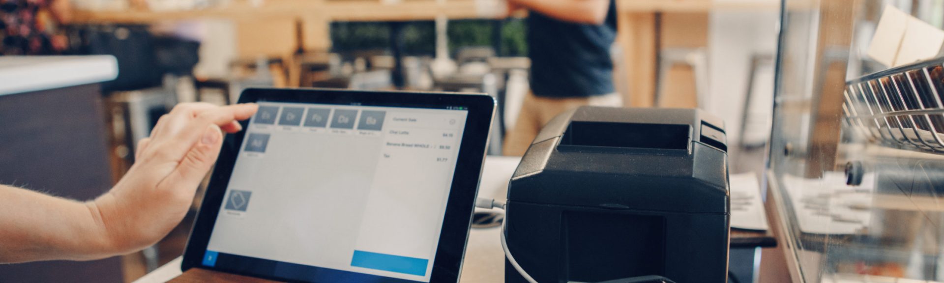 Closeup shot of caucasian cashier hands. Seller using touch pad for accepting client customer payment. Small business of coffee shop cafeteria.